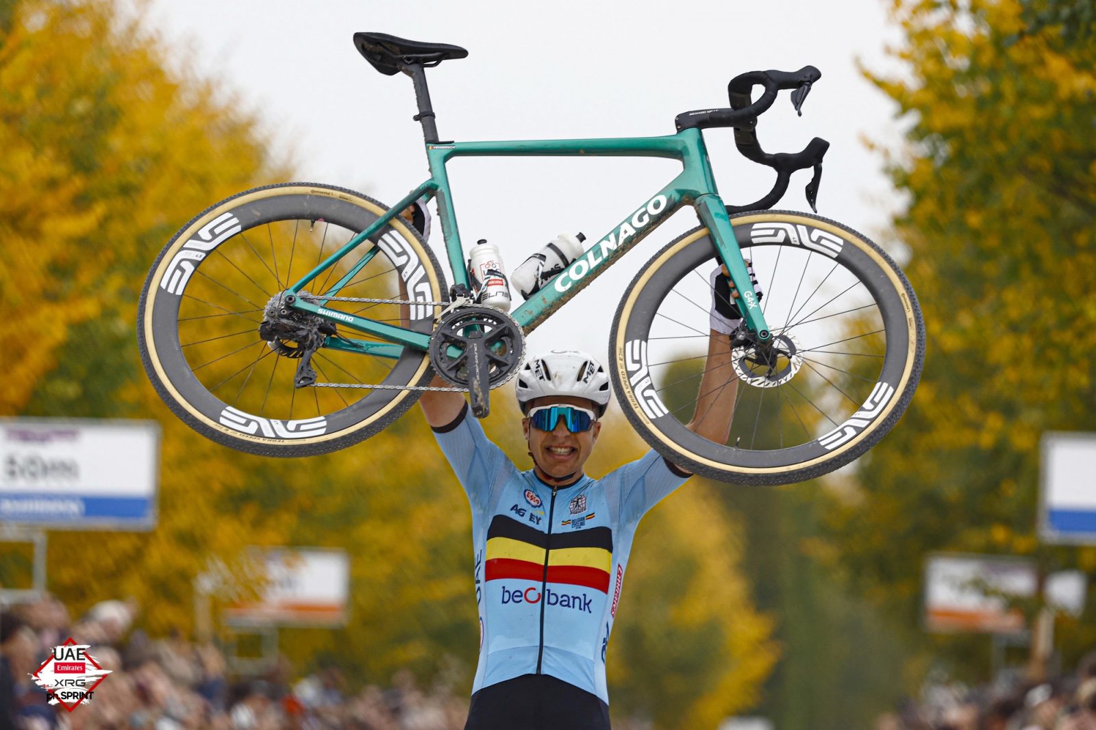 Vermeersch lifts his Colnago gravel bike aloft in celebration